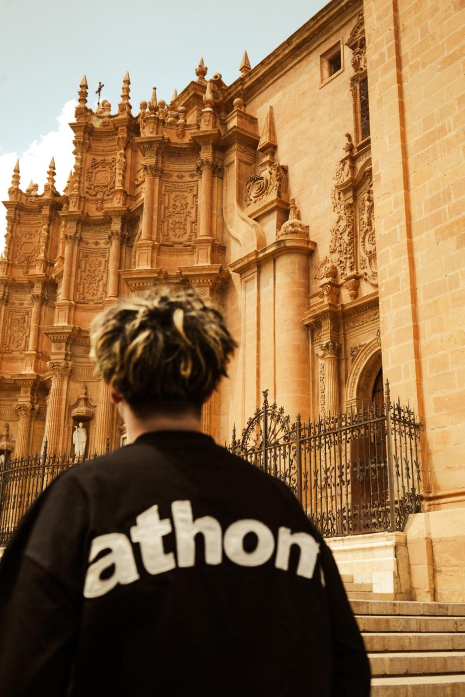 Arthur de dos devant une cathédrale baroque en Espagne