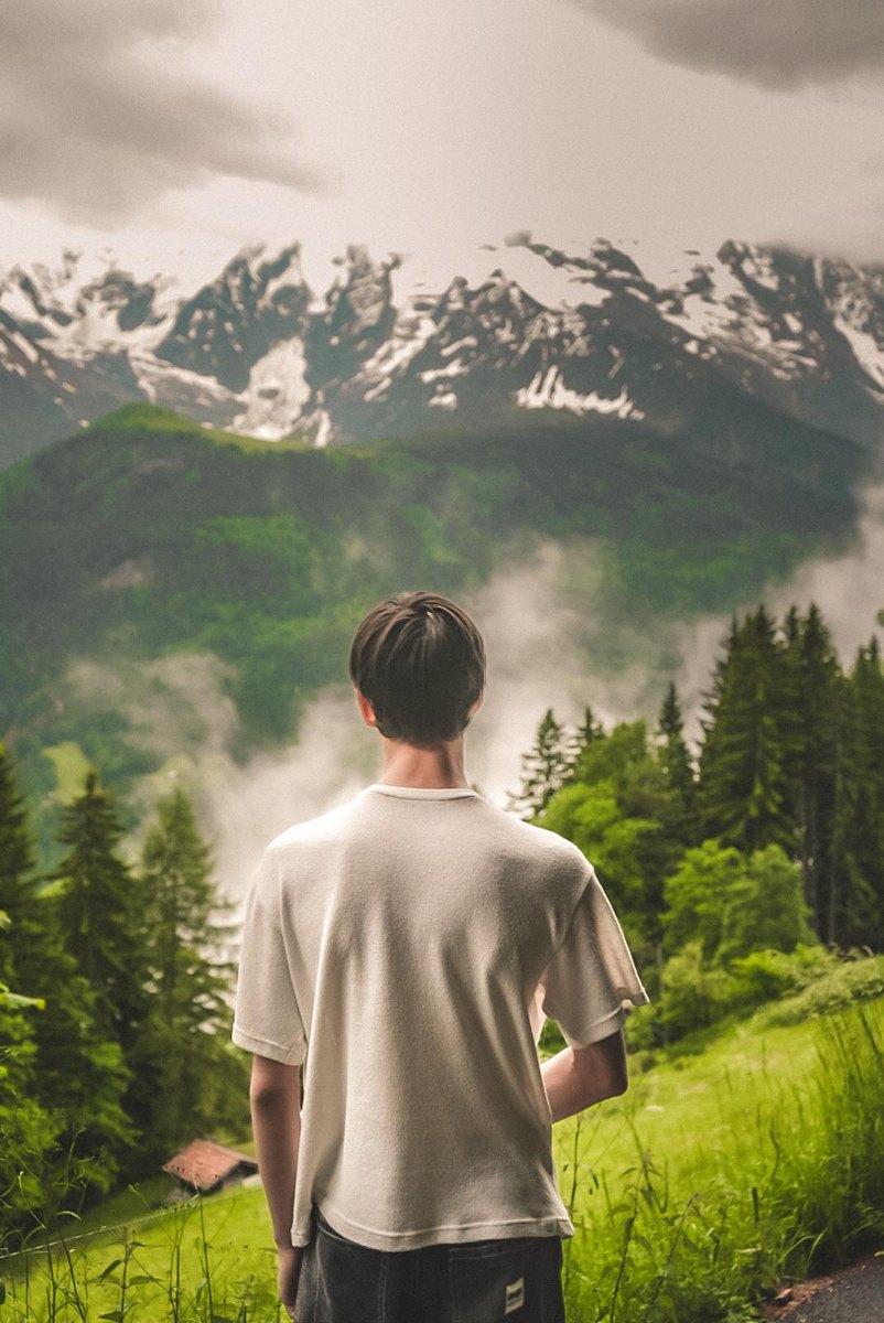 Arthur de dos face aux montagnes